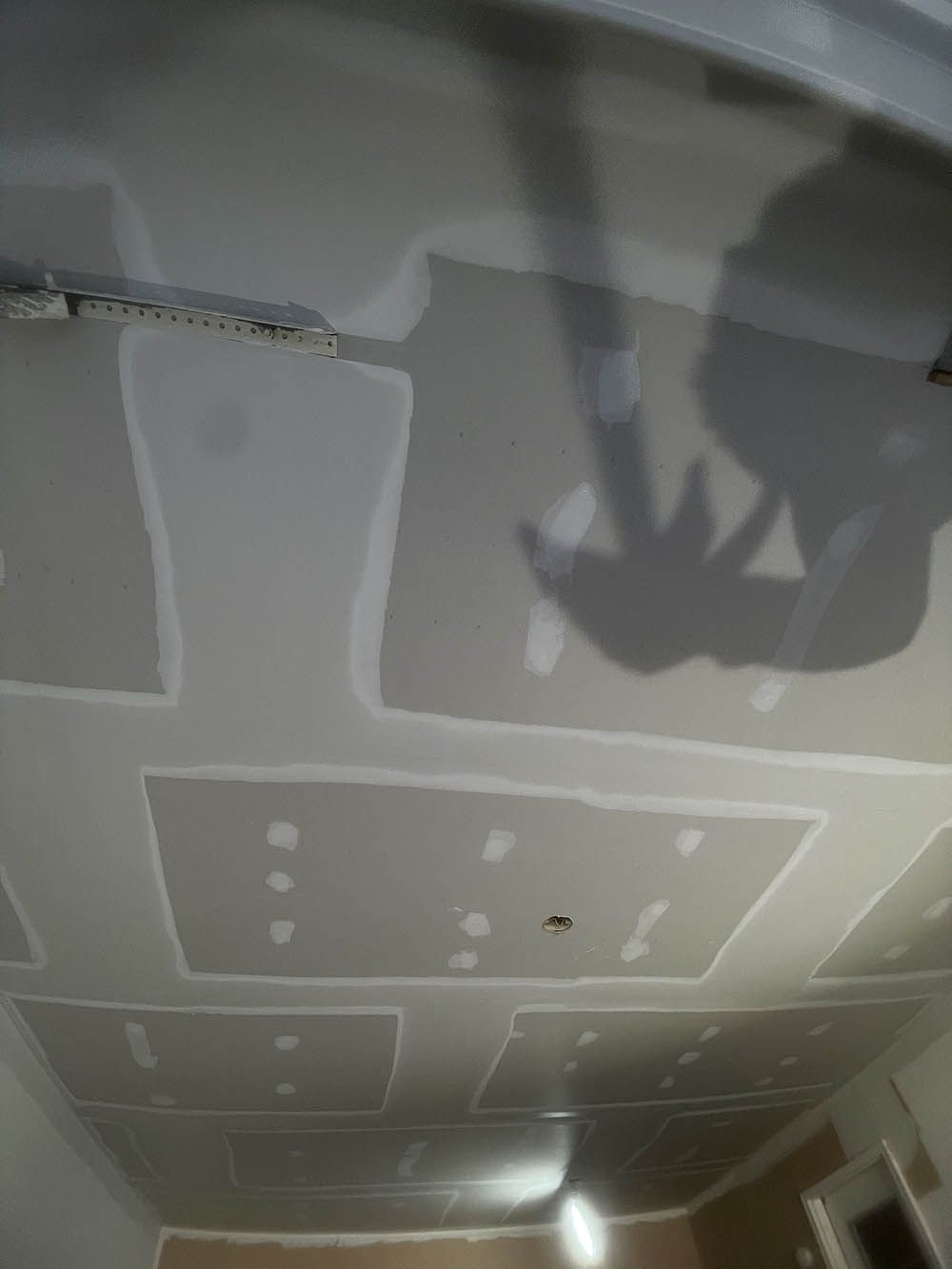 Upward view of multi-pass drywall finish floating flat across garage ceiling